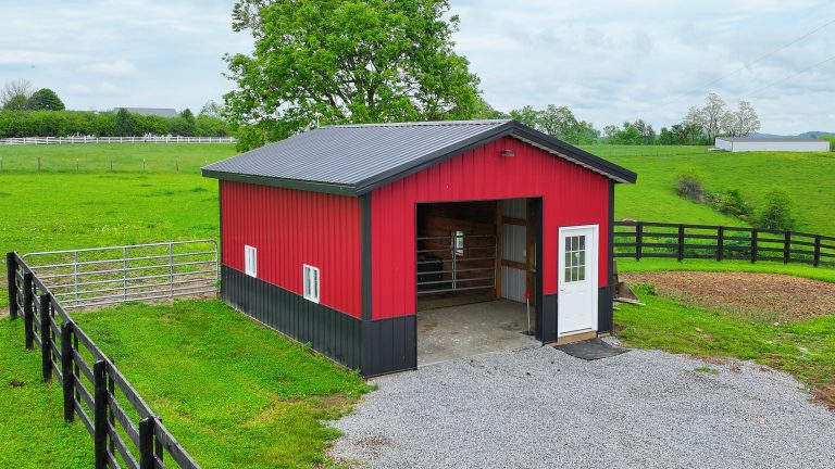 Colorful red and black barn in the country with a garage door